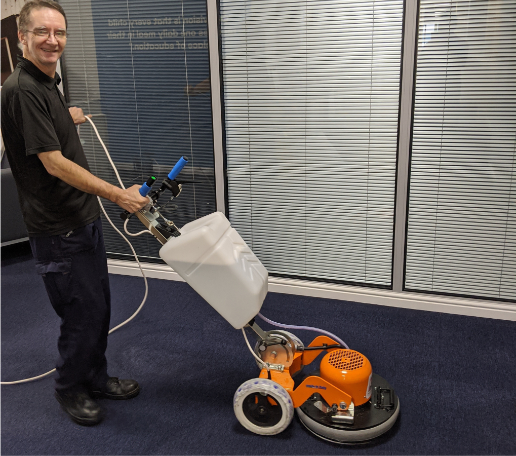 Professional cleaner with a commercial carpet cleaning machine 
